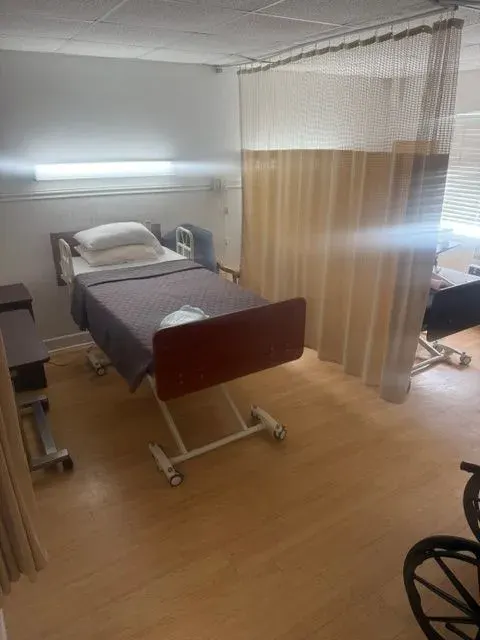 A semi-private resident room at Vivo Healthcare Sebring, divided by a privacy curtain